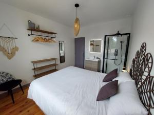 1 dormitorio con 1 cama blanca grande con almohadas en Gite des vendangeurs 4 étoiles - 10 personnes, en Bourg-sur-Gironde