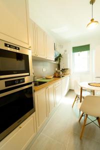 una cucina con mobili bianchi e tavolo di Brown Bear Apt. BOHO Style Bedroom w/ City View & free Parking a Braşov