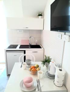una cocina con fregadero y un bol de fruta en una barra en Studio Apartments Regina en Bol