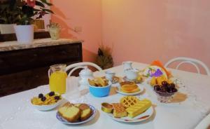 a table topped with plates of breakfast foods and orange juice at Affittacamere Centro Storico in Raiano