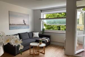 sala de estar con sofá y mesa en HAVEN STUUV - Zentral mit Balkon, en Bremerhaven