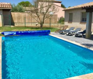 a swimming pool with blue water in a yard at Résidence Alpha Centauri in Carcassonne