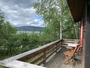 a wooden porch with a bench and a table on it at Fossumsanden Camping og Hytter in Fyresdal