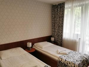 1 dormitorio con 2 camas y ventana en Ośrodek Natura, en Pokrzywna