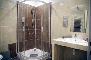La salle de bains est pourvue d'une douche et d'un lavabo. dans l'établissement Hotel Toppin, à Cavaillon