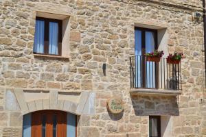 a stone building with three windows and a balcony at Rincón de Guara in Bierge