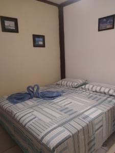 a bedroom with a bed with a blue blanket on it at Benu Suítes in Jericoacoara
