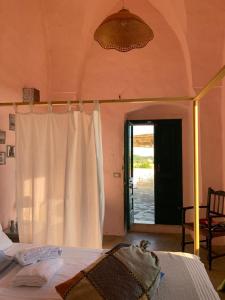 una camera con letto con tenda bianca di Agriturismo Tenuta Muzio a Sannicola