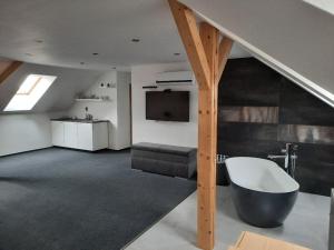 uma sala de estar com uma escada e uma banheira em Elvíra ubytování v soukromém em Kutná Hora
