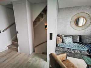 a room with a bed and a stairway with a mirror at Hotel Strand am Königshafen in List