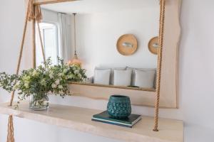 a mirror on a shelf with a vase and books at Blue Harbour Boutique in Ayia Napa