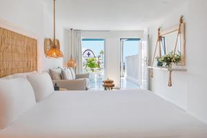 a bedroom with a white bed and a living room at Blue Harbour Boutique in Ayia Napa