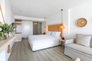 a bedroom with a white bed and a couch at Blue Harbour Boutique in Ayia Napa