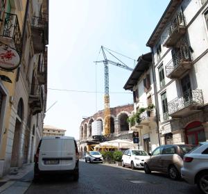 a white van parked on a city street with buildings at Leoncino Apartment in Verona