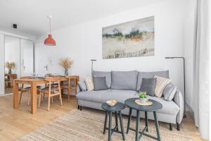 a living room with a couch and a table at Apartamenty Południowa 14 by Noclegi Renters in Dźwirzyno