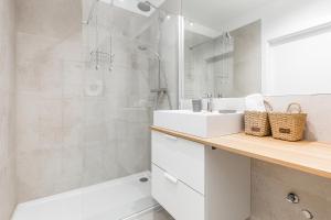 a bathroom with a white sink and a shower at Apartamenty Południowa 14 by Noclegi Renters in Dźwirzyno +40 photos