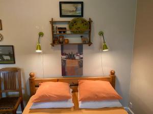 a bedroom with two orange pillows on a bed at Myrehøj Bed & Breakfast in Eskebjerg