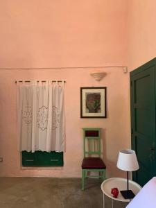 una camera con finestra, sedia e tavolo di Agriturismo Tenuta Muzio a Sannicola
