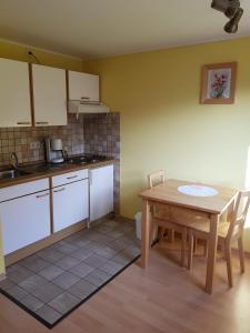 a kitchen with a wooden table and a table and chairs at Camping de L'Our Appartements in Vianden