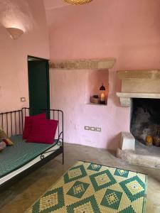 サンニコーラにあるAgriturismo Tenuta Muzioのリビングルーム(ベッド1台、暖炉付)