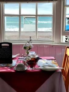 una mesa con un mantel rojo y blanco y un sidra de mesa en Lyndale Guest House, en Weymouth