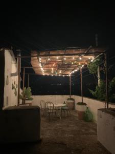 un patio con tavolo e sedie di notte di Agriturismo Tenuta Muzio a Sannicola