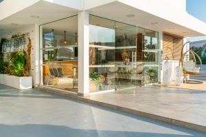 a glass building with chairs and tables in it at Blue Harbour Boutique in Ayia Napa