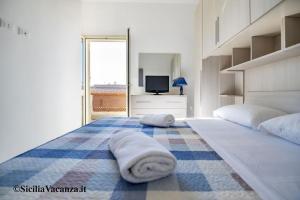 um quarto com uma cama grande e toalhas em House Calabernardo Sea Beach - Sicilia Vacanza em Calabernardo