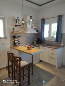a kitchen with a table and two chairs in it at Golden Mile STUDIO-APARTMENT in Ipsos