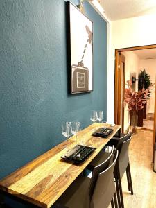 una mesa con copas de vino y una foto en la pared en Boutique Apartment am Bahnhof en Freiburg im Breisgau