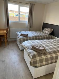 two beds sitting next to each other in a bedroom at Bucks accommodation in Aylesbury