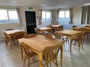 a classroom with wooden tables and chairs and windows at Bucks accommodation in Aylesbury