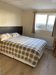 a bedroom with a bed with a plaid blanket at Bucks accommodation in Aylesbury