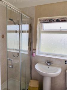 a bathroom with a sink and a glass shower at Crossroads in Holyhead