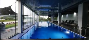 duży basen z błękitną wodą w budynku w obiekcie Apartament Lazurowy 53 z tarasem i SPA w mieście Gródek Nad Dunajcem