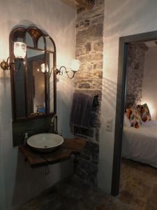 a bathroom with a sink and a mirror and a bed at Dos Arcos Usana in Aínsa