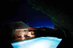 uma piscina no escuro à noite em Casa Ro-Ma, seaside villa with a heated pool em Banjole