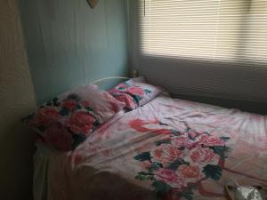 a bed in a bedroom with a flower blanket on it at Magnolia Cabin in Dartmouth