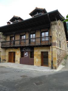 a building with a balcony on the side of it at Apartamentos Los Edules in Treceño