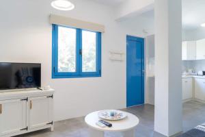 sala de estar con ventana azul y TV en Blue Moon Apartments, en Makrí Gialós