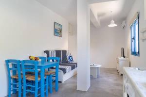 a room with a blue table and chairs and a couch at Blue Moon Apartments in Makry Gialos