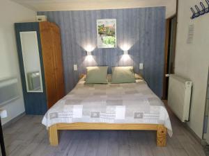 a bedroom with a large bed with two green pillows at Au Jardin près de l'ocean in Les Mathes