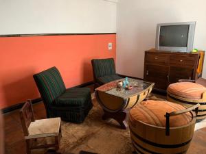 a living room with chairs and a tv and a table at Casa Cafayate in Cafayate