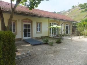 uma casa amarela com um guarda-chuva em frente em Villa Jordan em Radebeul