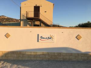 a building with a sign on the side of a wall at Terra di Suli in Custonaci