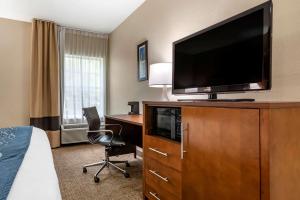 a hotel room with a bed and a television on a dresser at Comfort Inn Airport in Birmingham