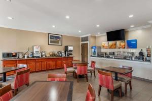 a restaurant with tables and chairs and a kitchen at Comfort Inn Airport in Birmingham