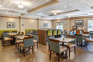 a restaurant with tables and chairs in a room at Comfort Suites Urbana Champaign, University Area in Champaign