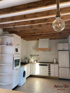 uma cozinha com electrodomésticos brancos e um tecto de madeira em Casa Rural Abuelo Teo em Campo de Criptana