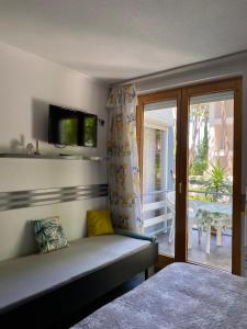 a bedroom with a bed and a balcony with a television at Pearl Home Siofok in Siófok